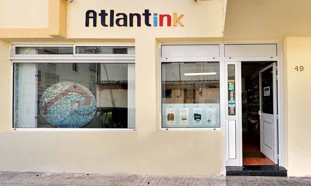 Fachada de la tienda Atlantink en Arrecife, con el escaparate y la puerta abierta